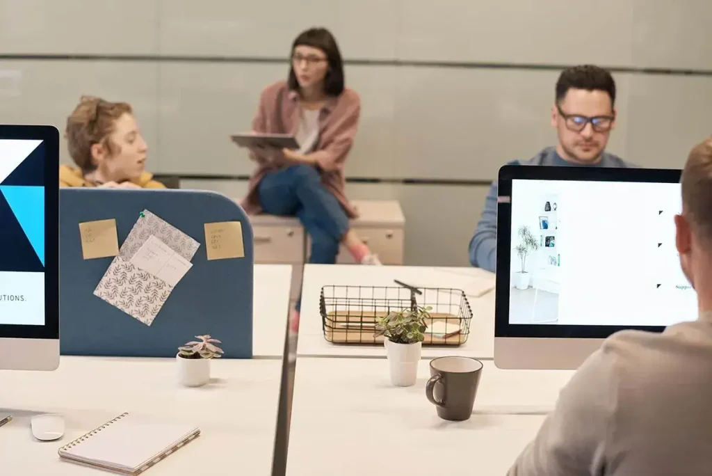 People in a modern open office working on computers.