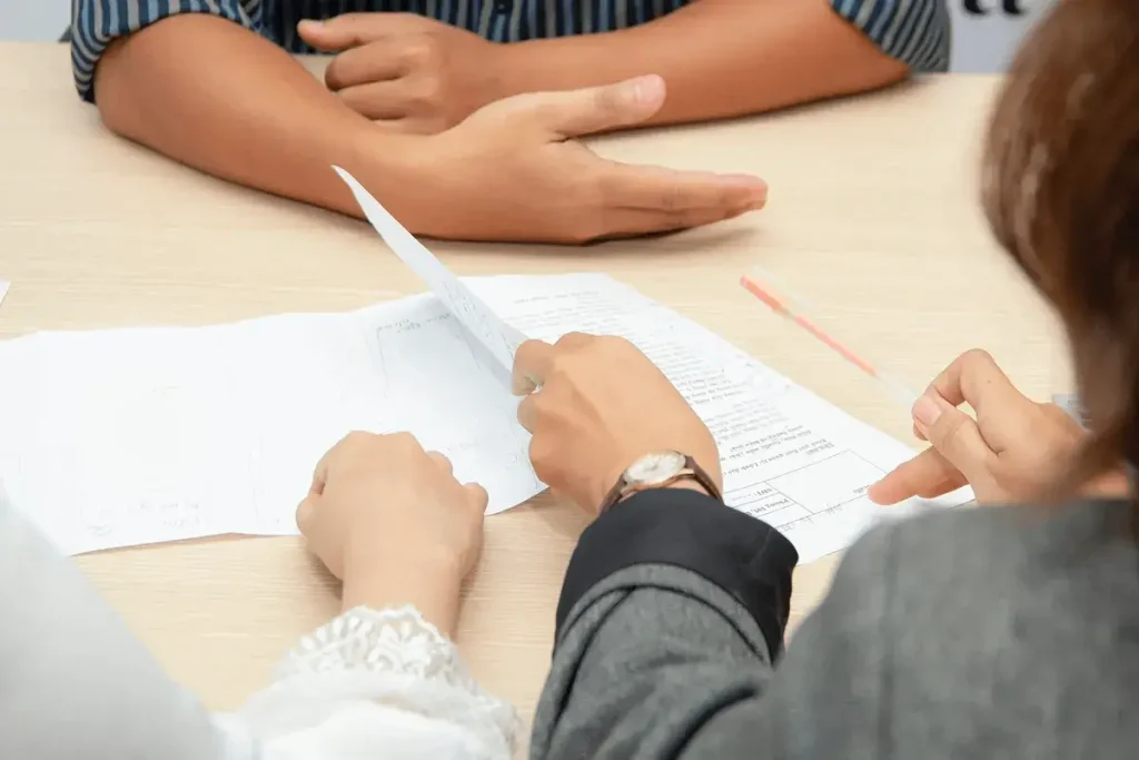 People at a table conducting an interview and looking at a resume.