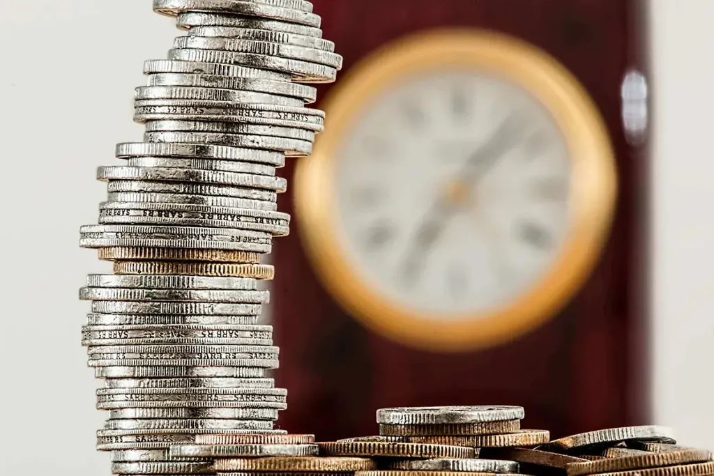 Stack of coins with more coins piled near by.