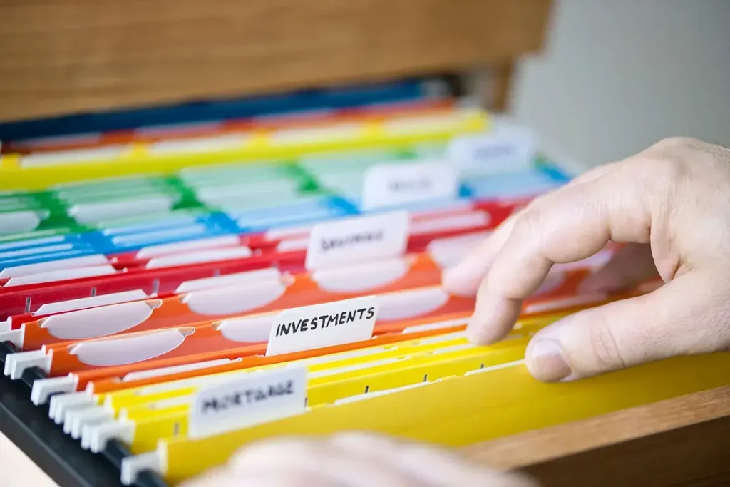 A file cabinet with the file labeled investments as the focus.