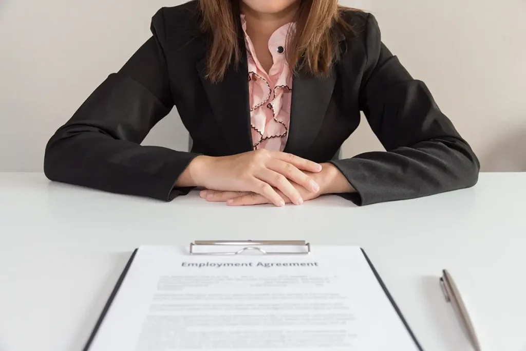 A clipboard with a employment agreement in front of a new employee.