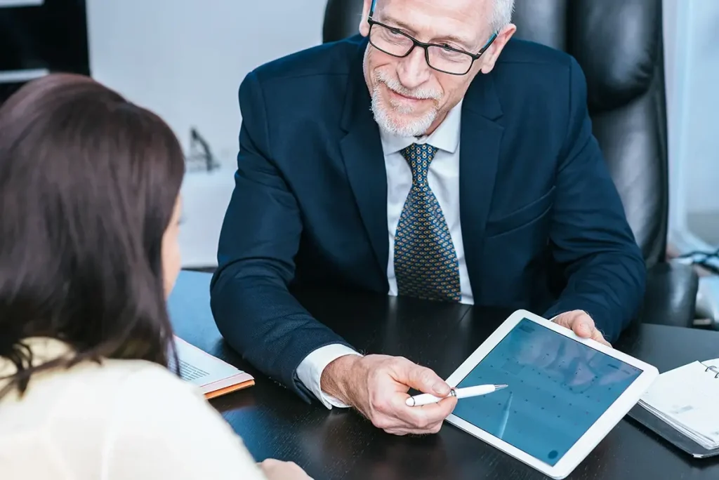 Accountant looking at a customer and pointing to the date on a calendar.