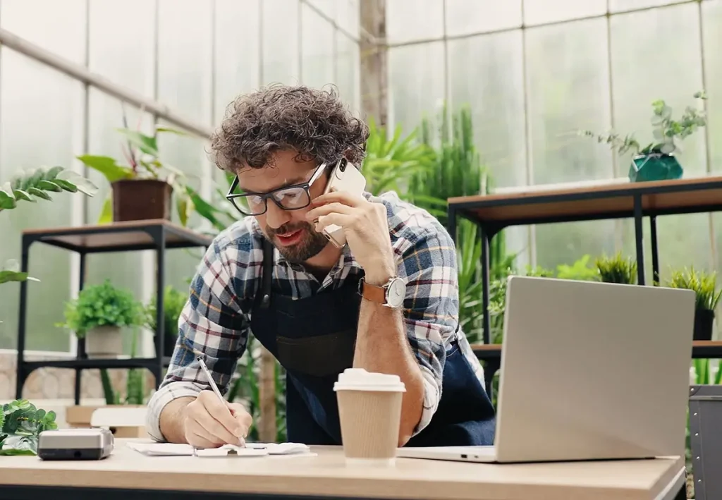 Business owner on the phone, making notes.