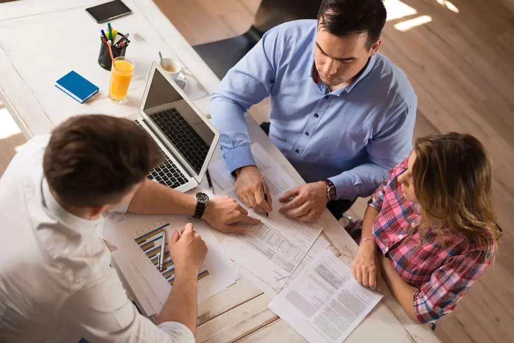 Accountant meeting with clients and looking at financial paperwork.