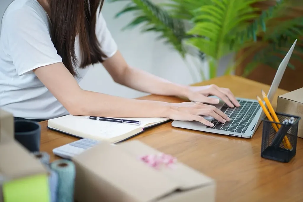 Woman using a laptop at a desk.