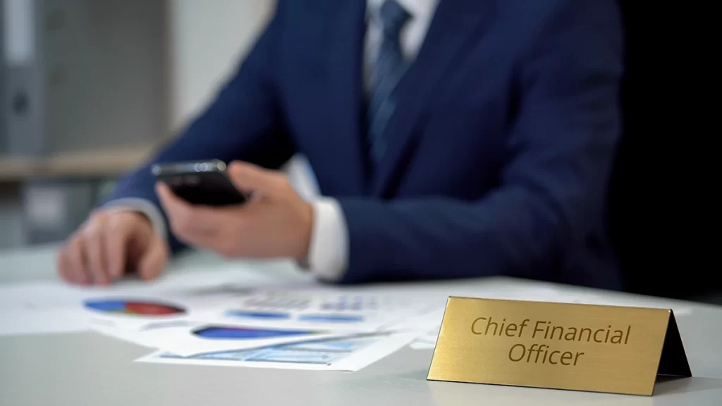 Chief financial officer checking phone and financial paperwork