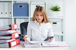Business woman calculates tax and payroll documents in office