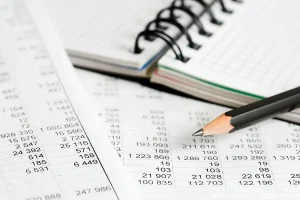 Financial accounting books with notebook and pencil.