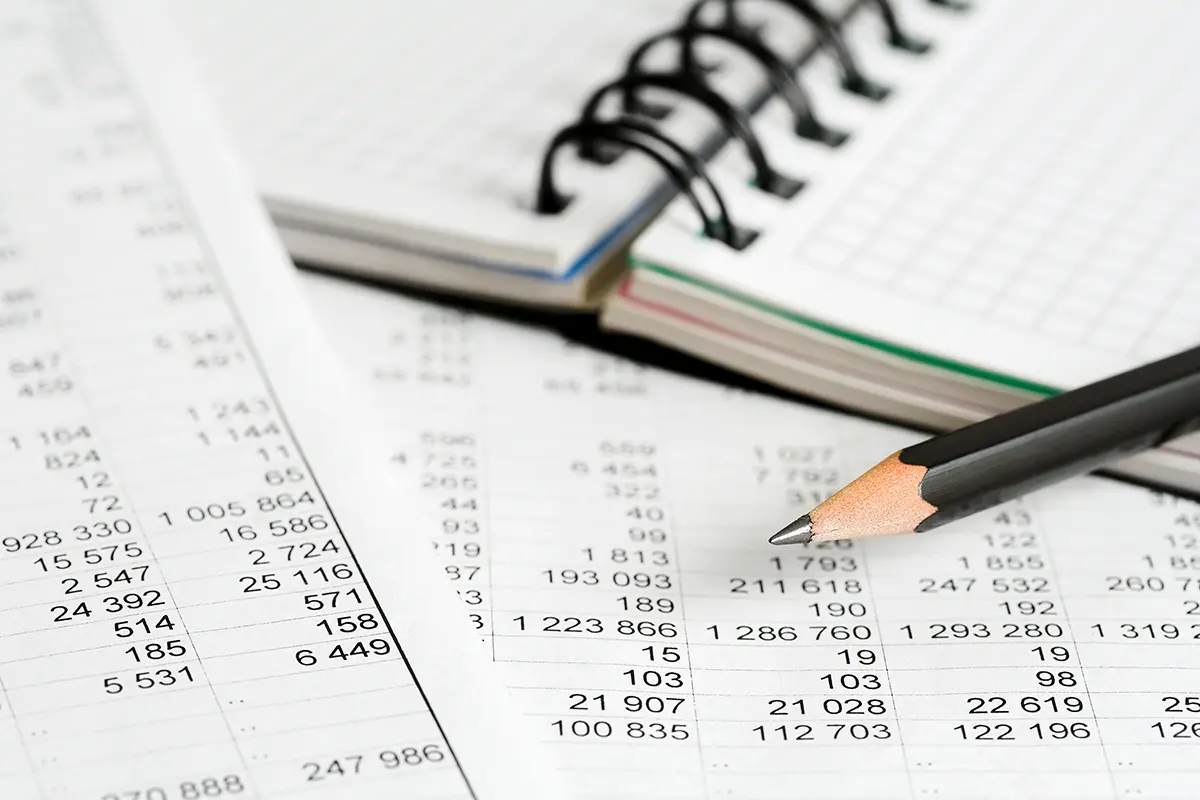 Financial accounting books with notebook and pencil.